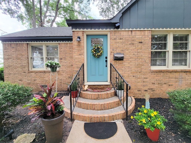 505 S Jackson St, Brenham, TX 77833 - doorway to property with board and batten siding, brick siding, and roof with shingles