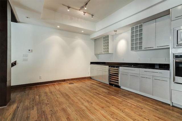 1820 Prospect St, Houston, TX 77004 - kitchen featuring dark countertops, wine cooler, a raised ceiling, light wood finished floors, and recessed lighting