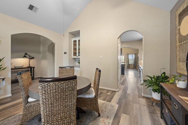 6619 Crystal Forest Trl, Katy, TX 77493 - dining room featuring arched walkways, wood finished floors, and high vaulted ceiling