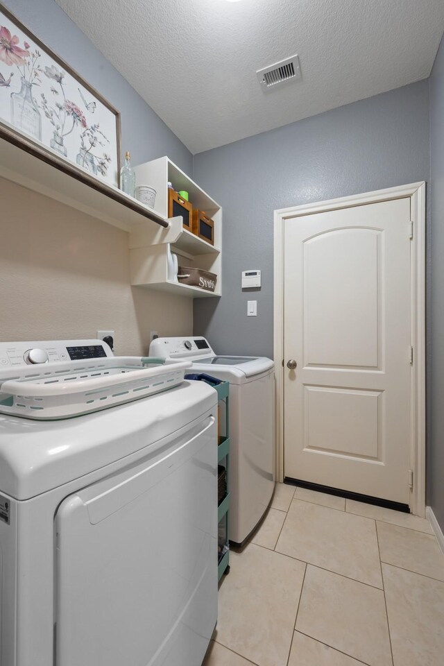 6619 Crystal Forest Trl, Katy, TX 77493 - laundry room featuring independent washer and dryer, light tile patterned floors, and a textured ceiling