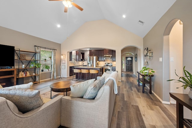 6619 Crystal Forest Trl, Katy, TX 77493 - living room with arched walkways, a ceiling fan, light wood-type flooring, high vaulted ceiling, and recessed lighting