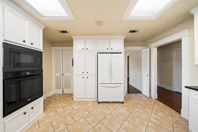 101 Fairway View Ln, Montgomery, TX 77356 - kitchen featuring black appliances, white cabinets, light tile patterned floors, and dark countertops
