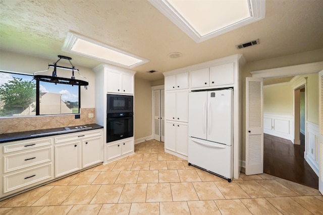 101 Fairway View Ln, Montgomery, TX 77356 - kitchen featuring black appliances, dark countertops, white cabinetry, light tile patterned floors, and tasteful backsplash