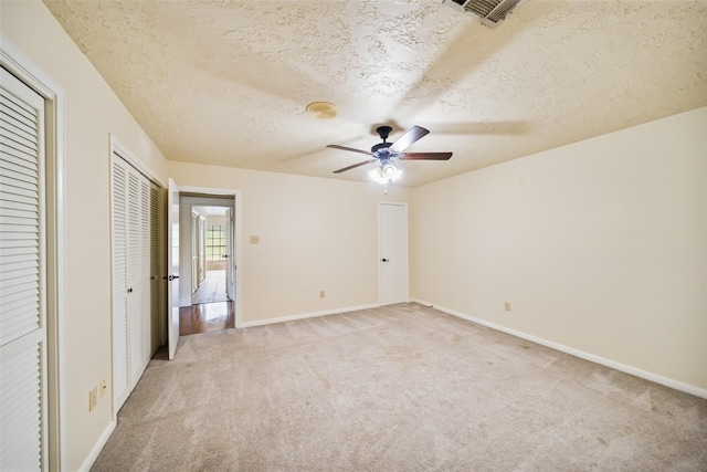 101 Fairway View Ln, Montgomery, TX 77356 - unfurnished bedroom featuring light carpet, multiple closets, a textured ceiling, and ceiling fan