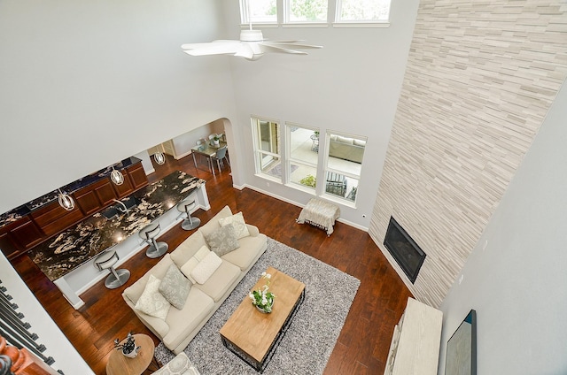 25718 Creek Ledge Dr, Katy, TX 77494 - living room with a high ceiling, a ceiling fan, arched walkways, a tiled fireplace, and wood finished floors