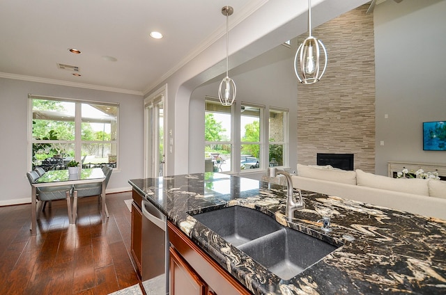25718 Creek Ledge Dr, Katy, TX 77494 - kitchen with stainless steel dishwasher, dark wood-style flooring, dark stone countertops, open floor plan, and decorative light fixtures