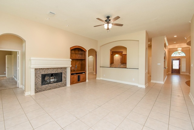 9610 Oakland Lake Way, Missouri City, TX 77459 - unfurnished living room featuring built in features, light tile patterned floors, a ceiling fan, a tiled fireplace, and recessed lighting