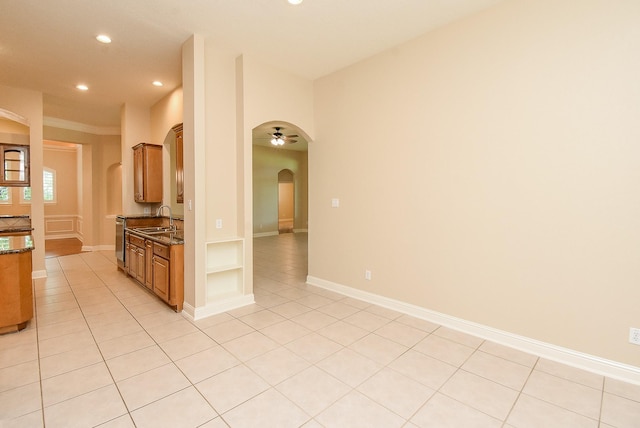9610 Oakland Lake Way, Missouri City, TX 77459 - kitchen featuring arched walkways, recessed lighting, brown cabinets, dark stone countertops, and light tile patterned floors