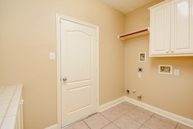 9610 Oakland Lake Way, Missouri City, TX 77459 - laundry area featuring hookup for an electric dryer, cabinet space, light tile patterned floors, washer hookup, and hookup for a gas dryer