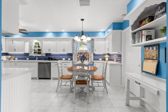 27225 Orth Ln, Conroe, TX 77385 - kitchen with stainless steel dishwasher, plenty of natural light, backsplash, and white cabinetry