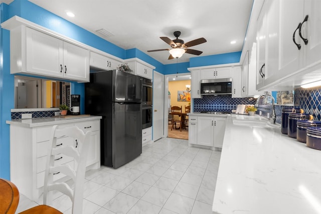 27225 Orth Ln, Conroe, TX 77385 - kitchen with stainless steel appliances, decorative backsplash, ceiling fan, white cabinetry, and recessed lighting