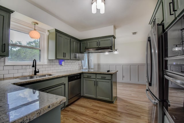 510 Daffodil St, Lake Jackson, TX 77566 - kitchen with stainless steel appliances, a peninsula, light stone countertops, light wood-style floors, and wainscoting