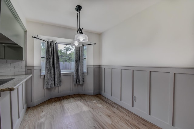 510 Daffodil St, Lake Jackson, TX 77566 - unfurnished dining area with light wood-type flooring, a wainscoted wall, and a decorative wall