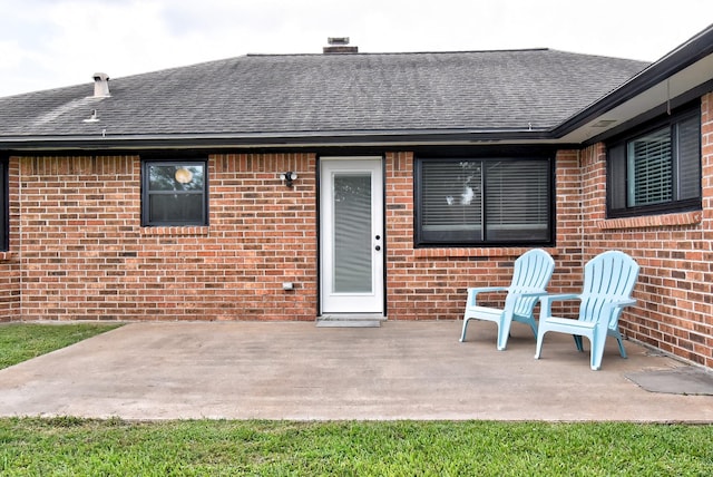 510 Daffodil St, Lake Jackson, TX 77566 - back of property with a shingled roof, brick siding, a patio area, and a chimney