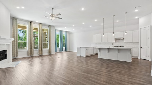 15139 Botanical Garden Dr, Conroe, TX 77302 - unfurnished living room featuring ceiling fan, recessed lighting, a high end fireplace, and dark wood-type flooring