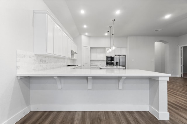 15139 Botanical Garden Dr, Conroe, TX 77302 - kitchen with appliances with stainless steel finishes, backsplash, arched walkways, white cabinetry, and recessed lighting