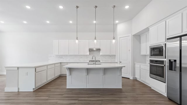 15139 Botanical Garden Dr, Conroe, TX 77302 - kitchen featuring stainless steel appliances, backsplash, light countertops, under cabinet range hood, and a peninsula
