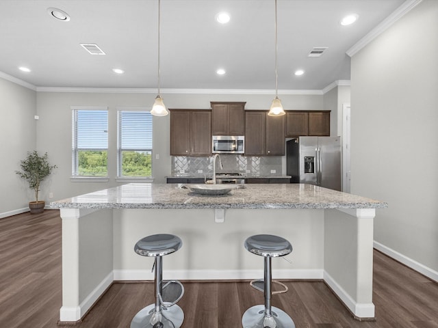 9618 Cambridge Manor Ln, Houston, TX 77045 - kitchen with stainless steel appliances, dark wood finished floors, a spacious island, ornamental molding, and decorative backsplash