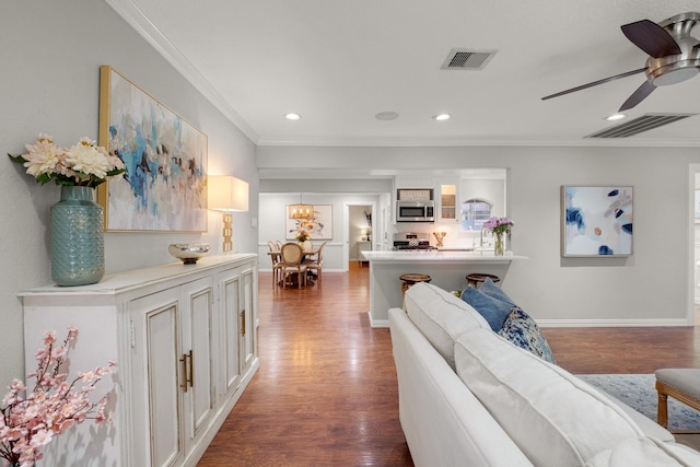 1838 Saxon Dr, Houston, TX 77018 - living area featuring dark wood-style flooring, crown molding, ceiling fan, and recessed lighting