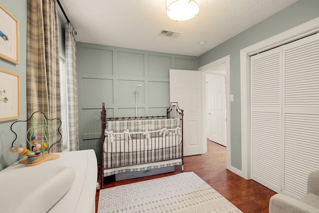 1838 Saxon Dr, Houston, TX 77018 - bedroom featuring dark wood-style floors, a decorative wall, and a closet