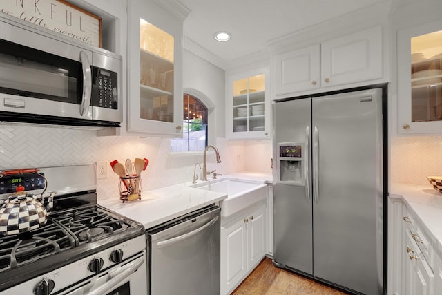1838 Saxon Dr, Houston, TX 77018 - kitchen with appliances with stainless steel finishes, white cabinets, ornamental molding, tasteful backsplash, and glass insert cabinets