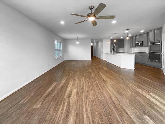 25621 Ramsey Heights Way, Porter, TX 77365 - unfurnished living room with ceiling fan, dark wood-type flooring, and recessed lighting