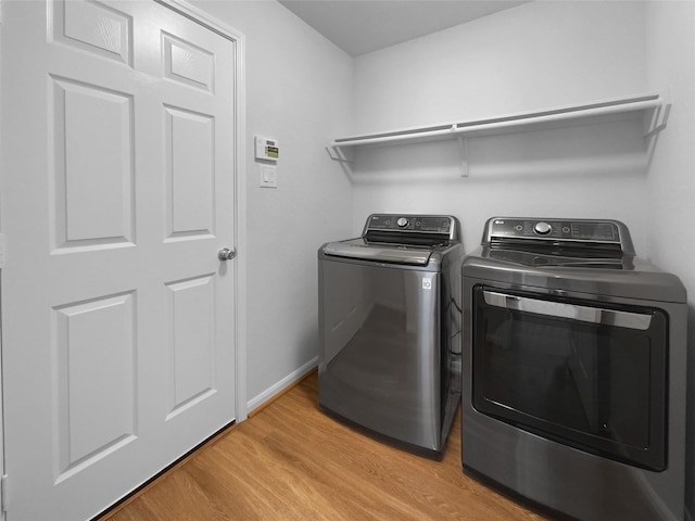 25621 Ramsey Heights Way, Porter, TX 77365 - laundry room with light wood finished floors and separate washer and dryer