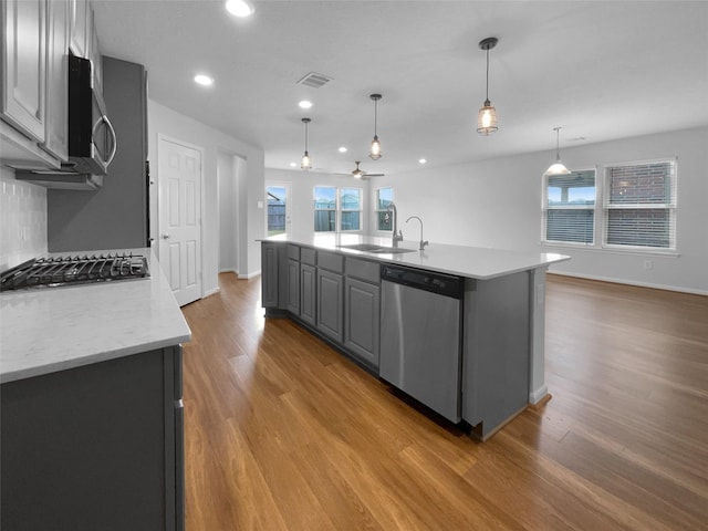 25621 Ramsey Heights Way, Porter, TX 77365 - kitchen featuring stainless steel appliances, light wood-style flooring, a center island with sink, recessed lighting, and a ceiling fan