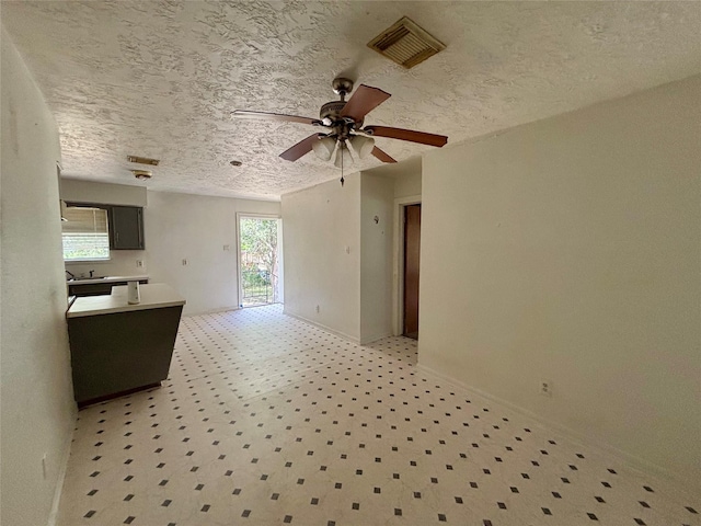 7947 Moore Dr, Pearland, TX 77584 - kitchen featuring plenty of natural light, a ceiling fan, a textured ceiling, light floors, and light countertops
