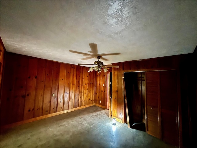7947 Moore Dr, Pearland, TX 77584 - unfurnished bedroom with wood walls, a closet, a ceiling fan, and a textured ceiling