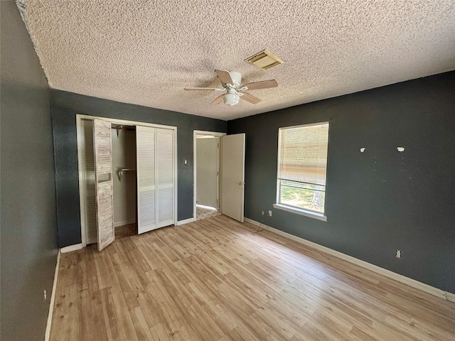7947 Moore Dr, Pearland, TX 77584 - unfurnished bedroom featuring light wood finished floors, a textured ceiling, a closet, and ceiling fan