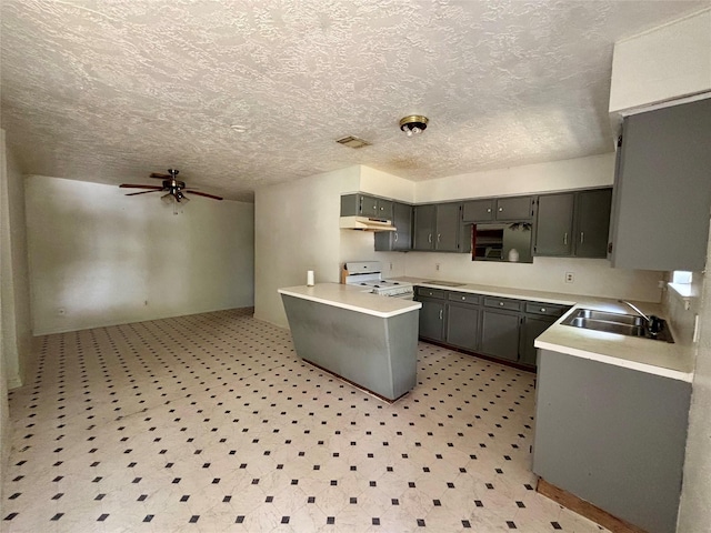 7947 Moore Dr, Pearland, TX 77584 - kitchen with white stove, under cabinet range hood, a ceiling fan, light countertops, and gray cabinetry