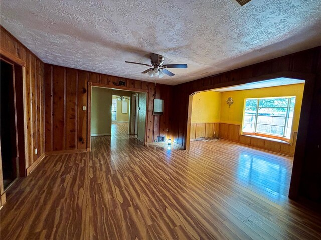 7947 Moore Dr, Pearland, TX 77584 - spare room featuring wood finished floors, a textured ceiling, wood walls, and ceiling fan