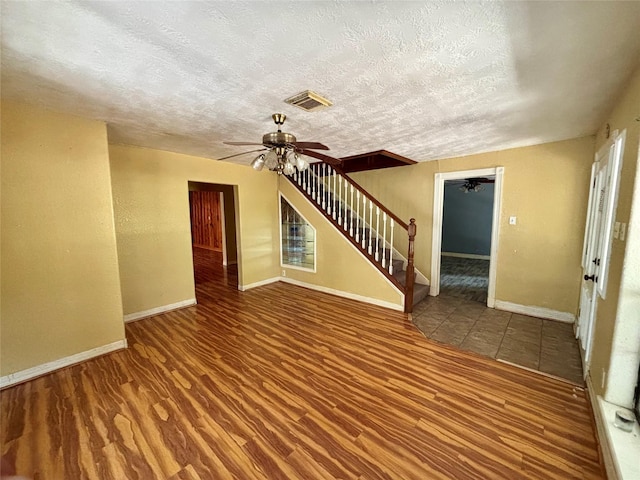 7947 Moore Dr, Pearland, TX 77584 - unfurnished living room featuring ceiling fan, stairs, wood finished floors, and a textured ceiling