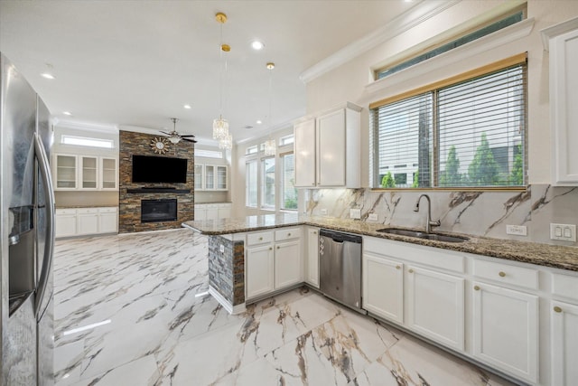 13205 Dartmoor Terrace Dr, Houston, TX 77077 - kitchen featuring appliances with stainless steel finishes, a fireplace, ornamental molding, ceiling fan, and white cabinets