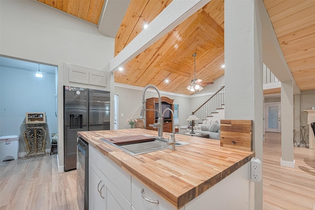 6170 Beech Dr, Montgomery, TX 77316 - kitchen with butcher block counters, open floor plan, light wood-style floors, white cabinets, and wood ceiling