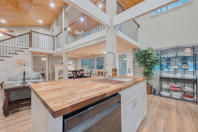 6170 Beech Dr, Montgomery, TX 77316 - kitchen featuring butcher block countertops, dishwasher, a high ceiling, open floor plan, and light wood-style flooring