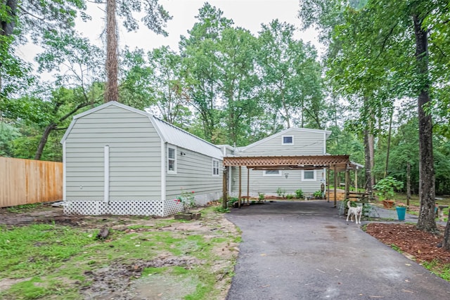 6170 Beech Dr, Montgomery, TX 77316 - view of front facade with driveway, a carport, a gambrel roof, and an outdoor structure