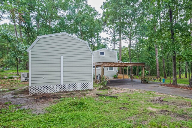 6170 Beech Dr, Montgomery, TX 77316 - view of side of property with a carport, a gambrel roof, and a storage unit