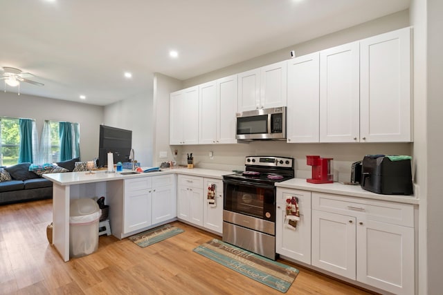 7921 Sparta St, Houston, TX 77028 - kitchen with stainless steel appliances, open floor plan, a peninsula, white cabinets, and recessed lighting