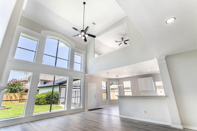 7147 Hot Creek Trce, Humble, TX 77346 - unfurnished living room featuring ceiling fan, wood finished floors, a towering ceiling, recessed lighting, and decorative columns