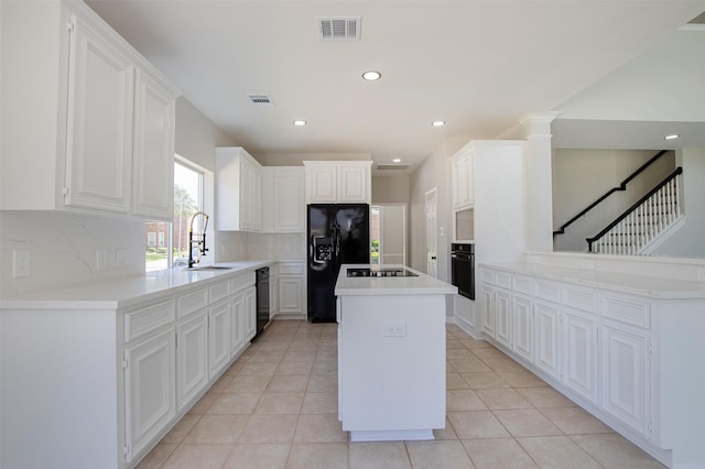 7147 Hot Creek Trce, Humble, TX 77346 - kitchen with black appliances, a kitchen island, white cabinets, light countertops, and recessed lighting