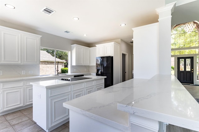7147 Hot Creek Trce, Humble, TX 77346 - kitchen with black appliances, a peninsula, white cabinetry, recessed lighting, and light stone countertops