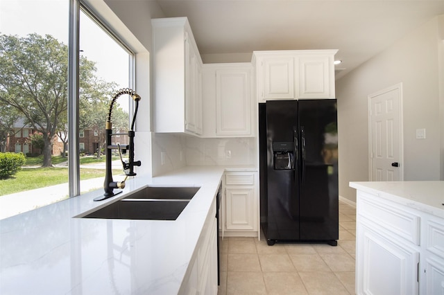 7147 Hot Creek Trce, Humble, TX 77346 - kitchen with black fridge with ice dispenser, light tile patterned floors, plenty of natural light, and decorative backsplash