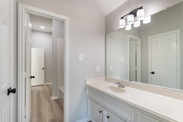 7147 Hot Creek Trce, Humble, TX 77346 - bathroom with wood finished floors, vanity, and vaulted ceiling