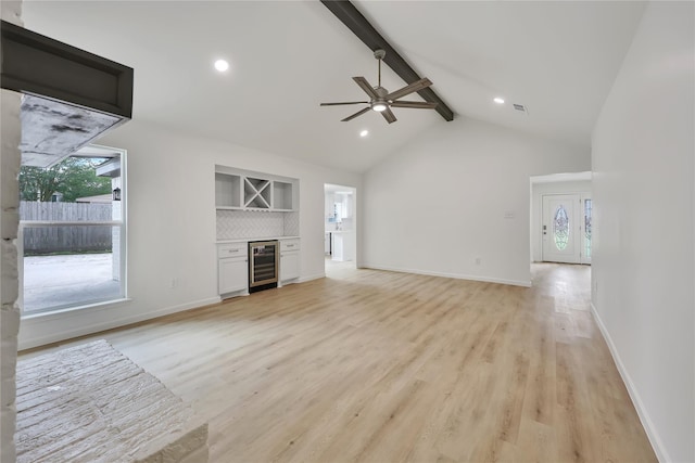 1503 Bamwick Dr, Houston, TX 77090 - unfurnished living room featuring beverage cooler, beam ceiling, plenty of natural light, light wood finished floors, and high vaulted ceiling