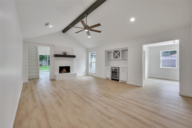 1503 Bamwick Dr, Houston, TX 77090 - unfurnished living room with beverage cooler, a fireplace, a ceiling fan, a bar, and plenty of natural light