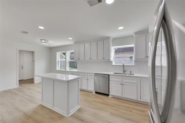 1503 Bamwick Dr, Houston, TX 77090 - kitchen with stainless steel appliances, decorative backsplash, light countertops, light wood-style flooring, and recessed lighting