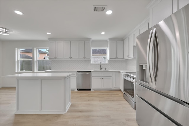 1503 Bamwick Dr, Houston, TX 77090 - kitchen featuring appliances with stainless steel finishes, backsplash, light countertops, light wood finished floors, and recessed lighting