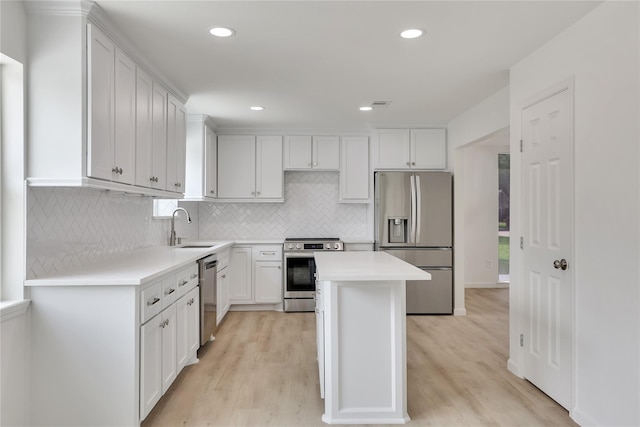 1503 Bamwick Dr, Houston, TX 77090 - kitchen featuring appliances with stainless steel finishes, light countertops, light wood finished floors, a kitchen island, and recessed lighting